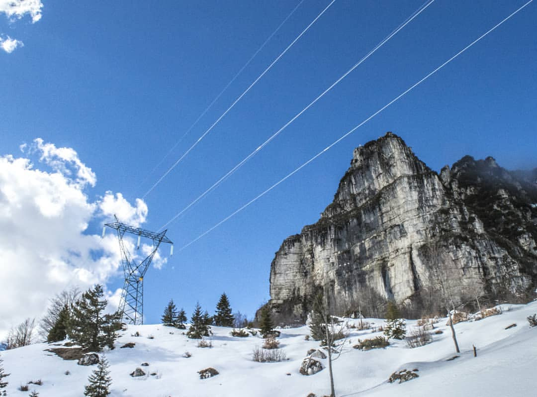 a snowy mountain with a cable tower
